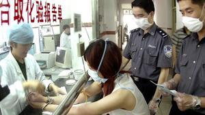 zentauroepp1320134 china out   a woman suspect in handcuffs gets tested for sar200107162849