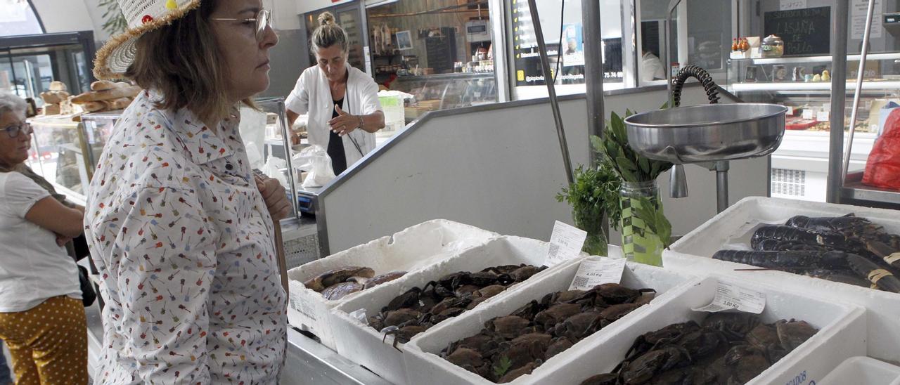 Una mujer observa las nécoras y bogavantes a la venta en la plaza vilagarciana, ayer.