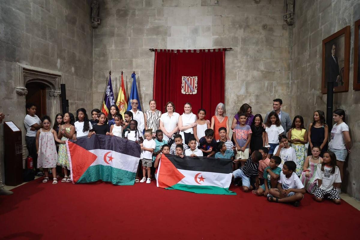 La presidenta del Govern, Marga Prohens, y el resto de autoridades, posando con los niños saharauis en el Consolat de Mar