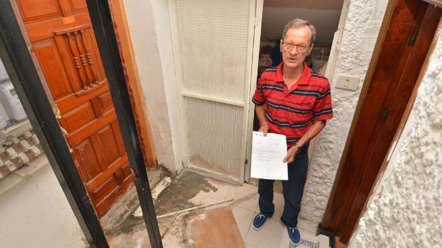 Manuel Miranda entre la puerta de su casa y la de la vivienda afectada por las aguas fecales.