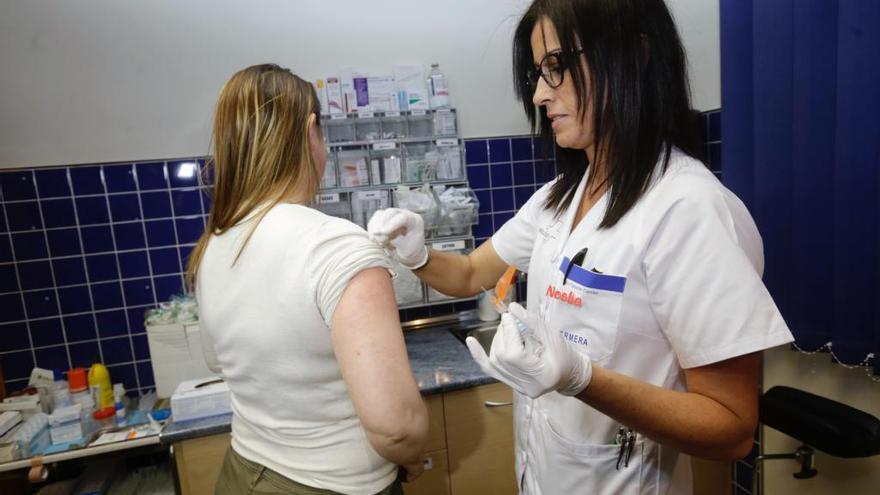 Ponen la vacuna contra la gripe este lunes a una mujer.