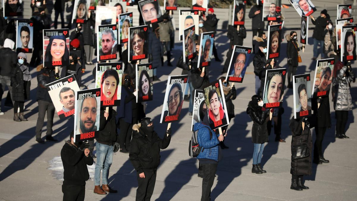 FILE PHOTO: People hold placards with images of the victims of the downing of Ukraine International Airlines flight PS752, which was shot down near Tehran by Iran's Revolutionary Guards, as they gather to take part in a march to mark its first anniversary, in Toronto, Ontario, Canada January 8, 2021. REUTERS/Carlos Osorio/File Photo