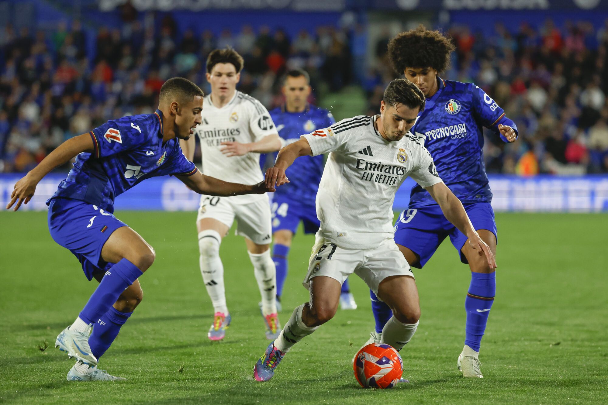 GETAFE (MADRID), 23/04/2025.- El centrocampista del Real Madrid, Brahim Díaz (c), se lleva el balón ante los jugadores del Getafe durante el partido de la jornada 33 de LaLiga que Getafe CF y Real Madrid disputan hoy miércoles en el Coliseum de Getafe. EFE/Juanjo Martín.