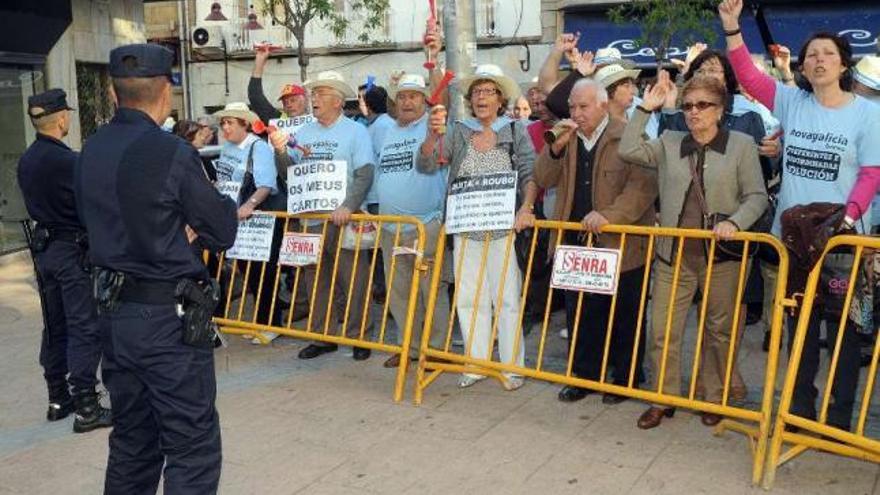 Varios afectados discutieron con Rafael Louzán al finalizar el acto en Novagalicia Banco.  // G. Santos