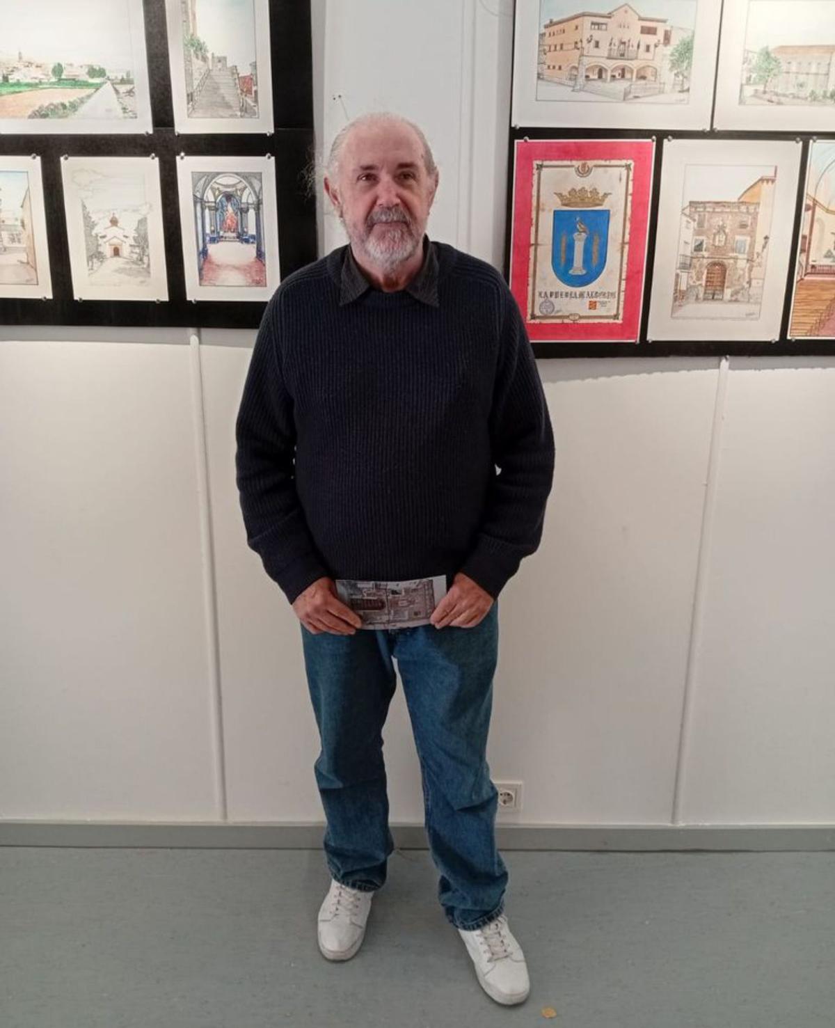 Miguel V. Murillo, artista local, posa con sus obras.