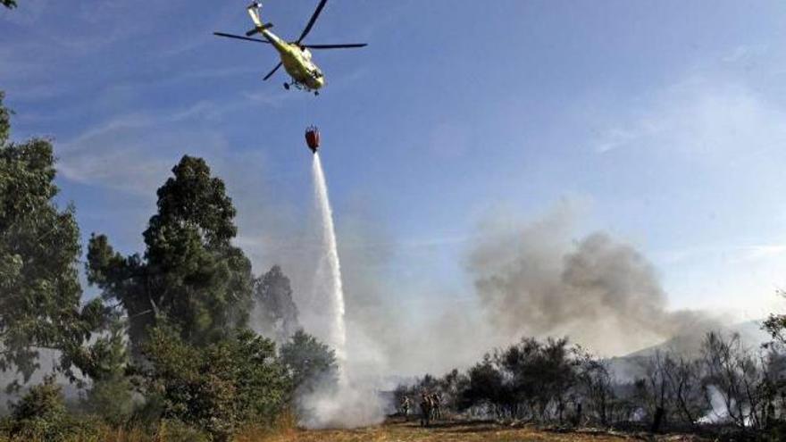 Un helicóptero descarga agua sobre un punto del incendio de Vidueiros.  // Bernabé/Luismy