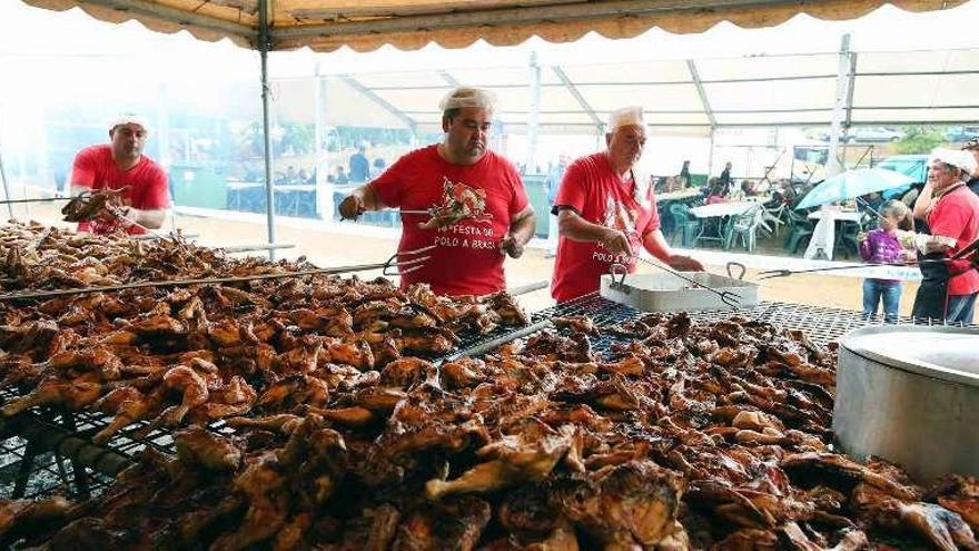 Miembros de la organización asando los pollos. // A. H.