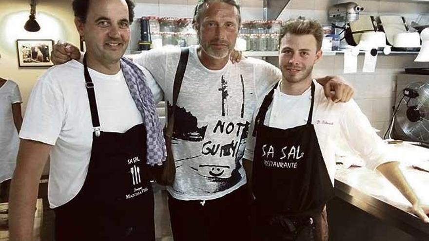 Mads Mikkelsen flanqueado por Mario Stephan (i), dueño del restaurante Sa Sal, y el cocinero (d).