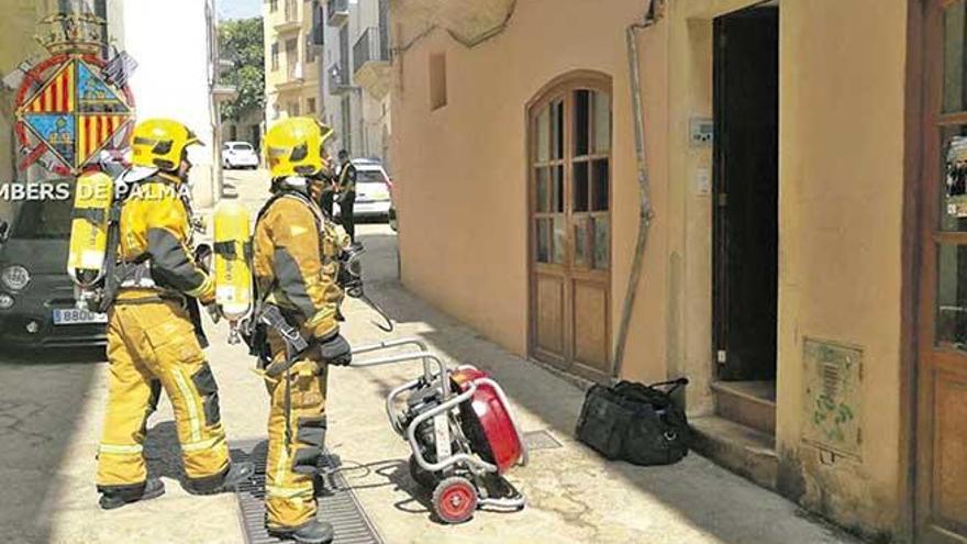 Dos bomberos, en el edificio de la calle Sant Pere, en Palma, donde se declaró el incendio.