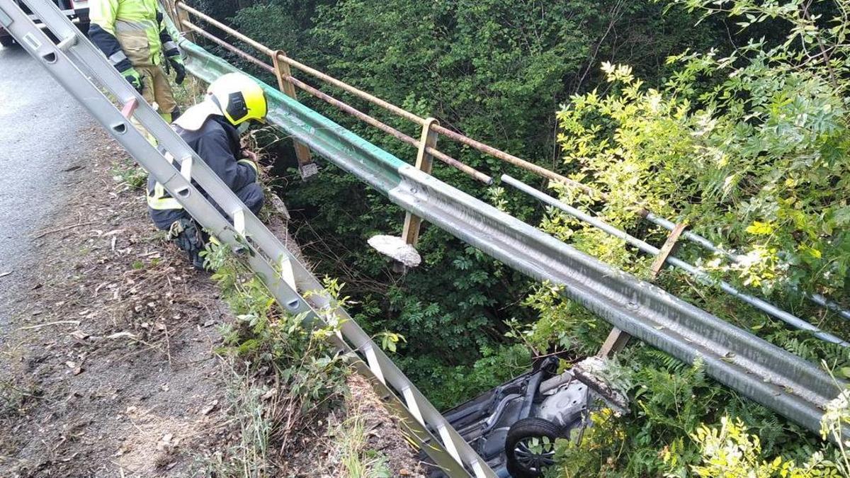 Efectivos del GES de Curtis intervienen para retirar el vehículo que se cayó hoy al río Mendo en un accidente en Oza-Cesuras.