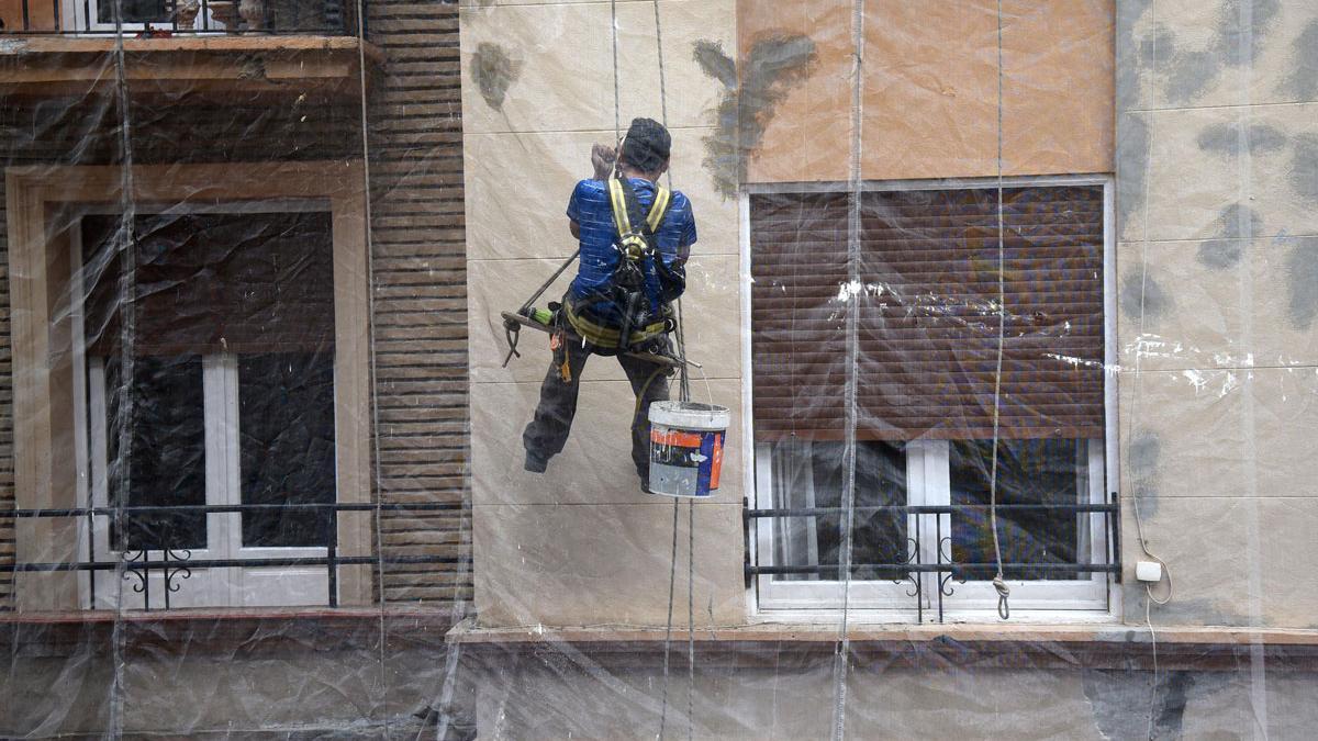 Trabajador en la fachada de un edificio en rehabilitación