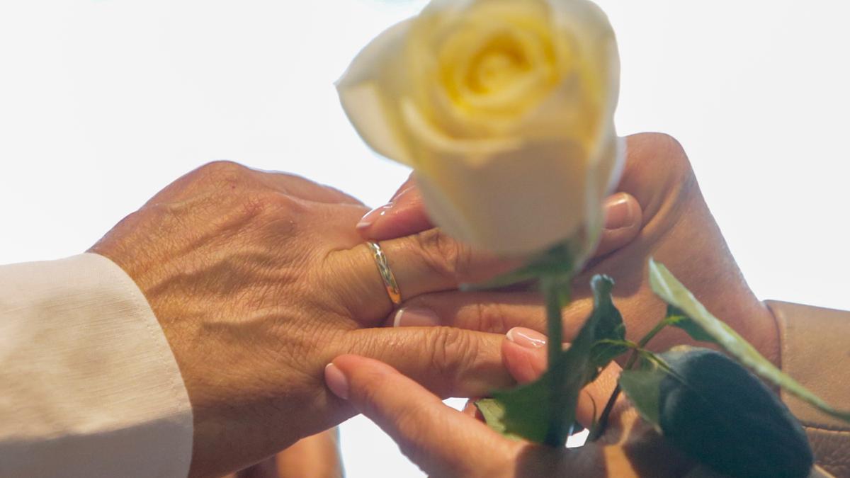 Una pareja se coloca las alianzas durante una boda.