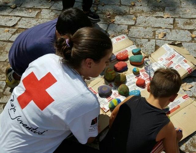 Voluntaria de Cruz Roja con niños en una actividad.