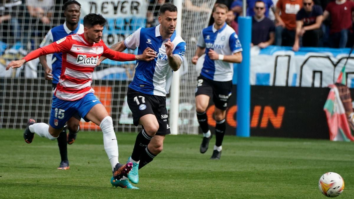 El futbolista del Alavés Edgar Méndez (c) se enfrenta aCarlos Neva (i), del Granada, durante su partido de la 29ª jornada de LaLiga Santander de fútbol disputado este sábado en el Estadio de Mendizorroza de Vitoria.