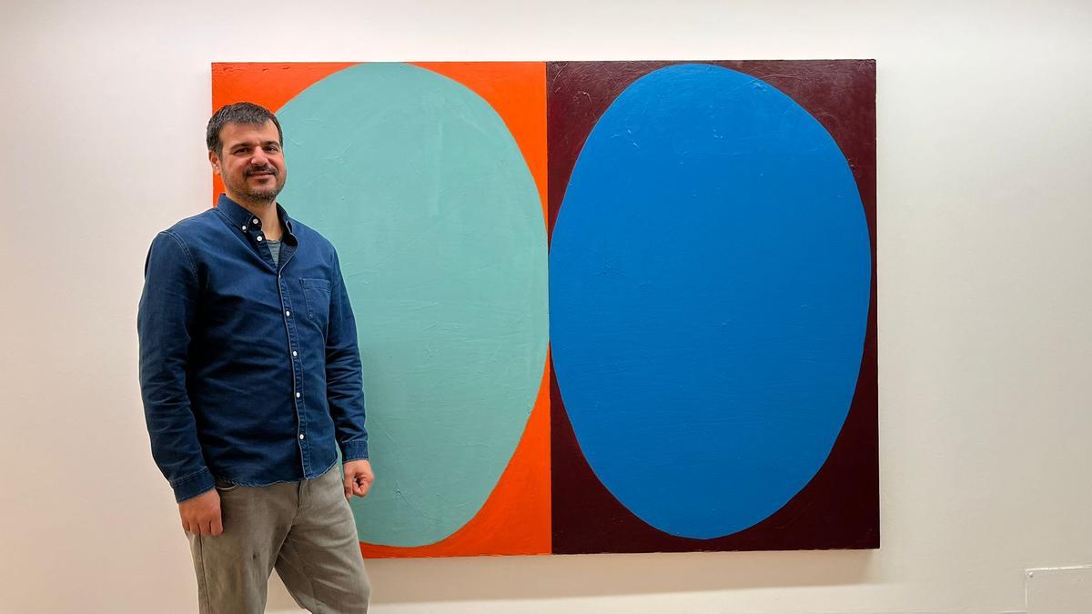 El artista, junto a uno de los cuadros expuestos.