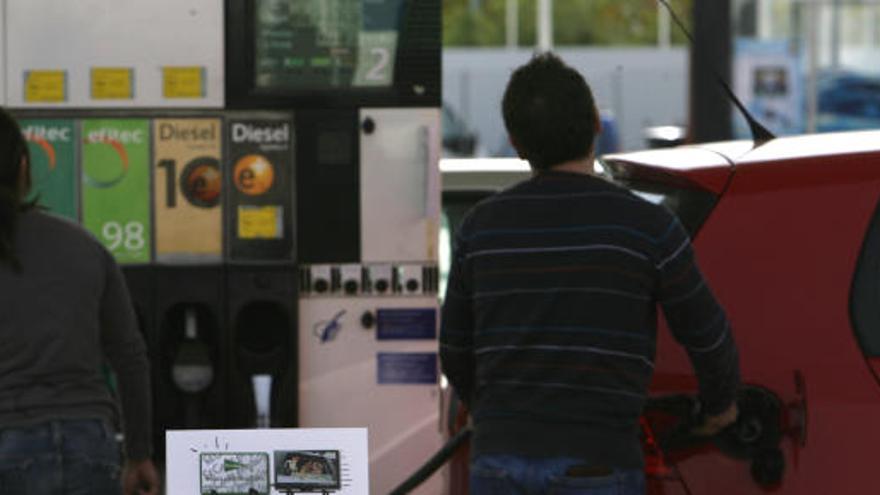 Un hombre pone gasolina en su coche.