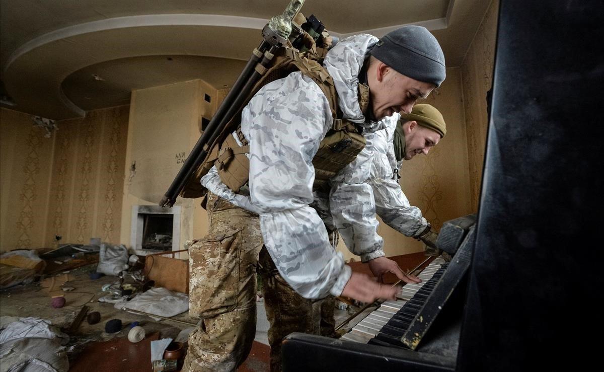 Dos miembros de las Fuerzas Armadas de Ucrania tocan el piano en una casa destruida, cerca de su posición en la línea del frente en la región de Donetsk, Ucrania.