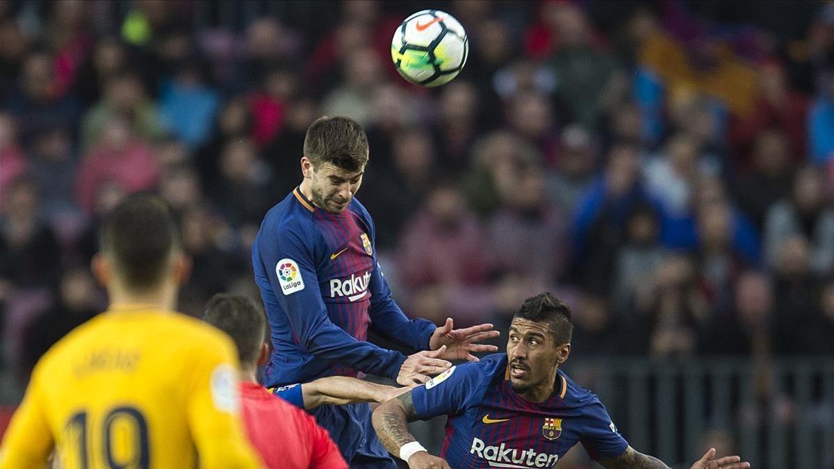 Piqué despeja el balón de cabeza en el duelo contra el Atlético de Madrid.