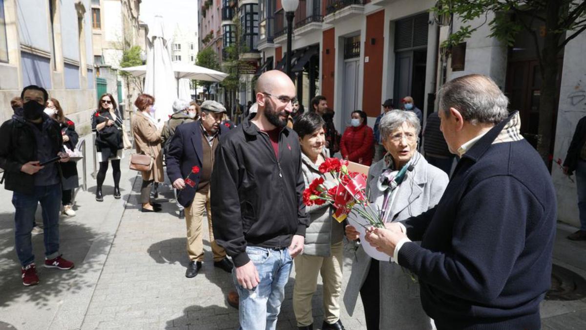 Por la izquierda, Álvaro Granda, Enriqueta Ortega y Faustino Sabio, ayer, con sus claveles antes del homenaje, en la calle La Merced.