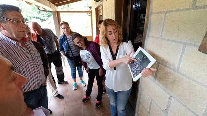 La Alcaldesa muestra las imágenes de la ladera a los vecinos, ayer, en la reunión.