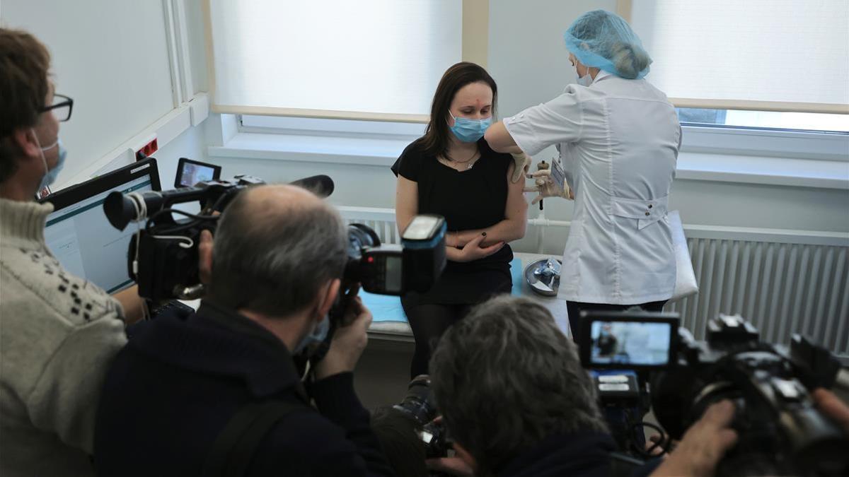 Unos periodistas presentes cuando una mujer recibe un pinchazo mientras le inyectan la vacuna Sputnik V.