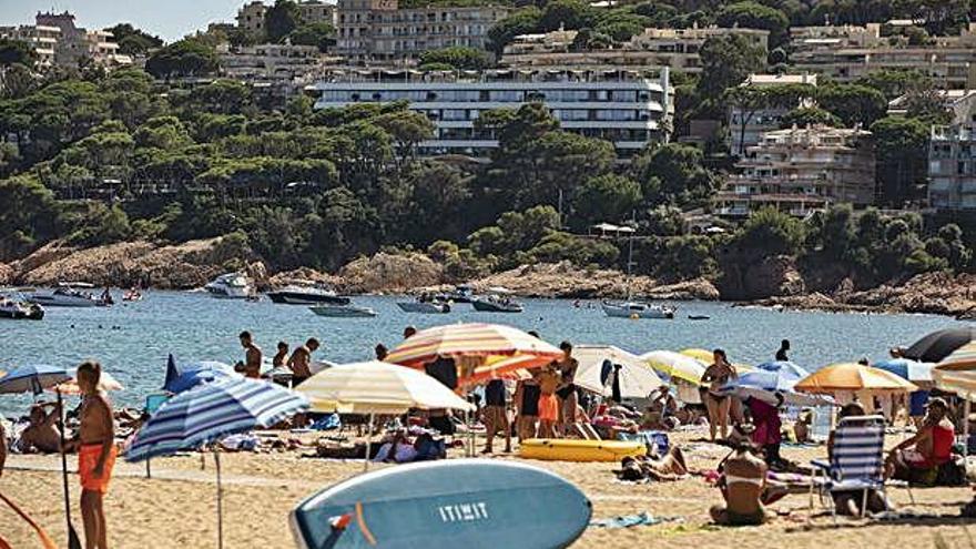 Turistes a la platja de Sant Feliu de Guíxols, en una imatge d&#039;arxiu.