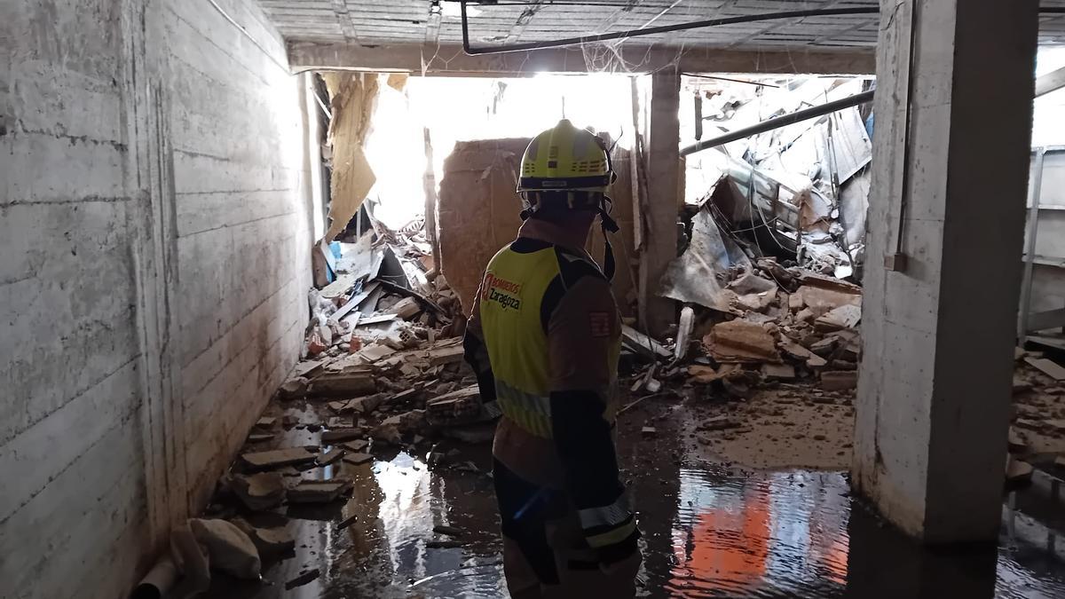 Un bombero de Zaragoza en el local afectado tras el derrumbe.