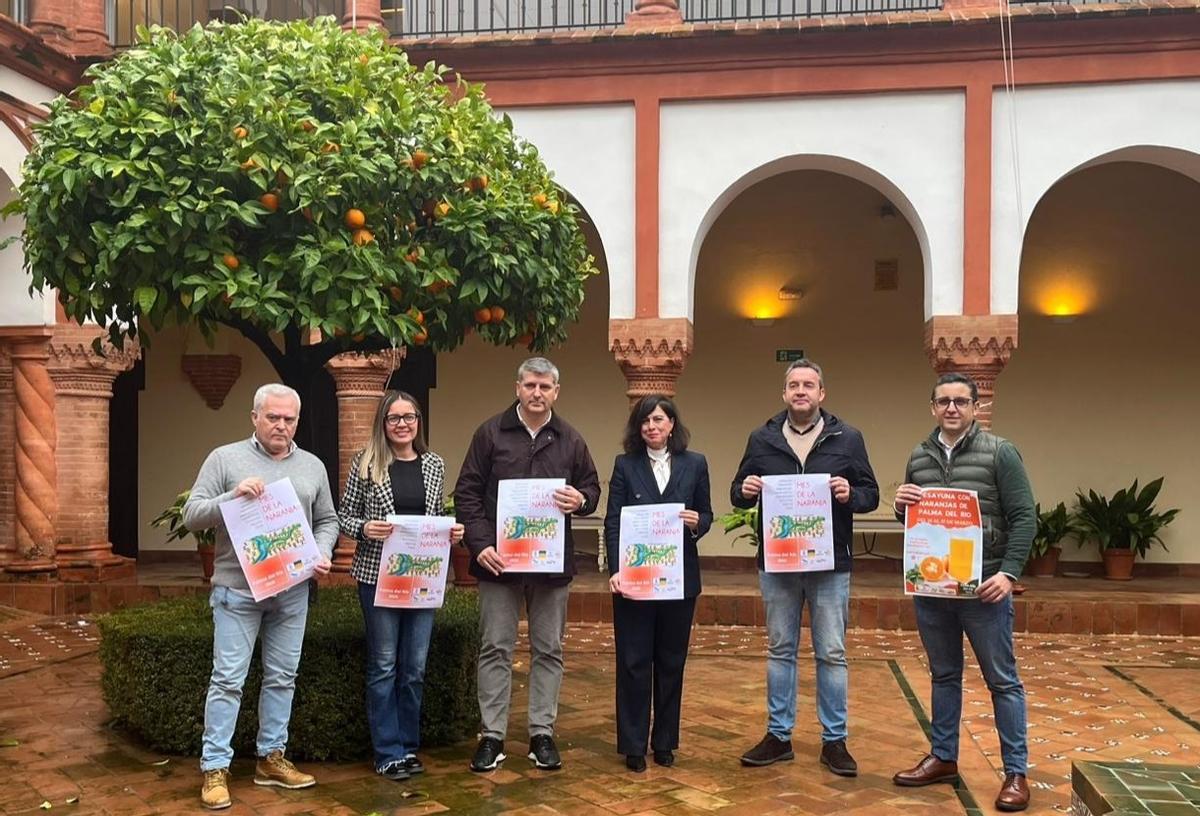 Autoridades y empresarios muestran el cartel anunciador del Mes de la Naranja de Palma del Río.