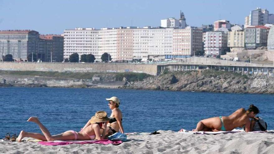 Bañistas toman el sol en la playa coruñesa del Orzán.