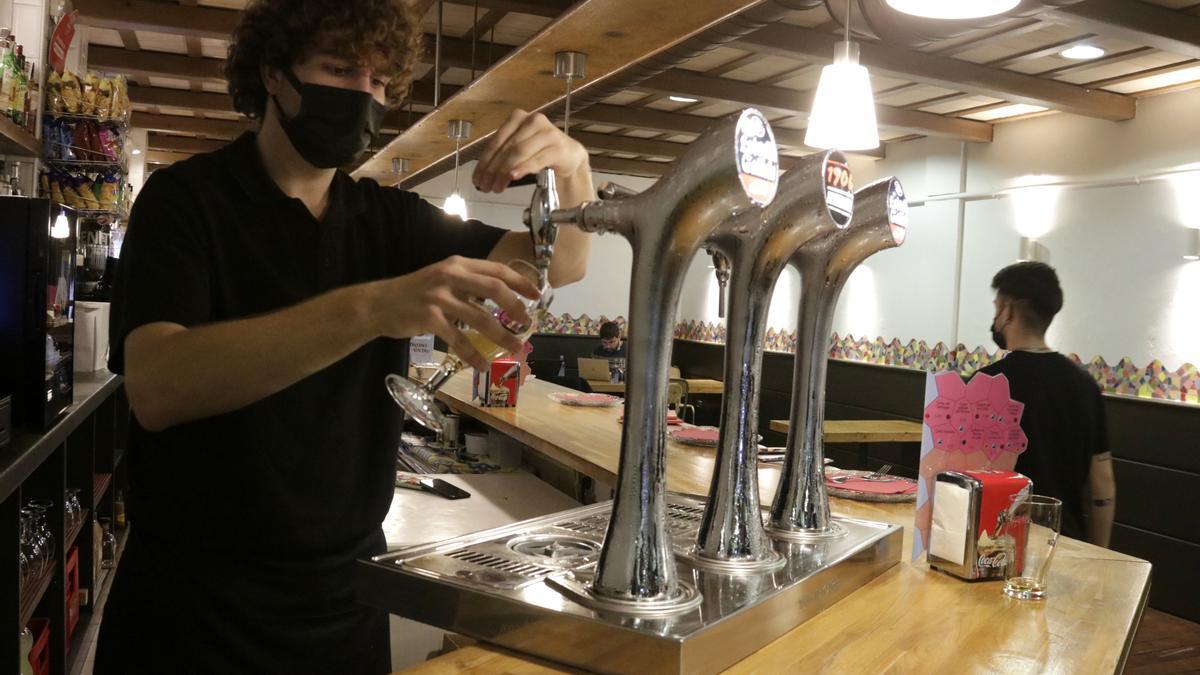 Un cambrer serveix una cervesa en un bar de Santa Coloma de Gramenet