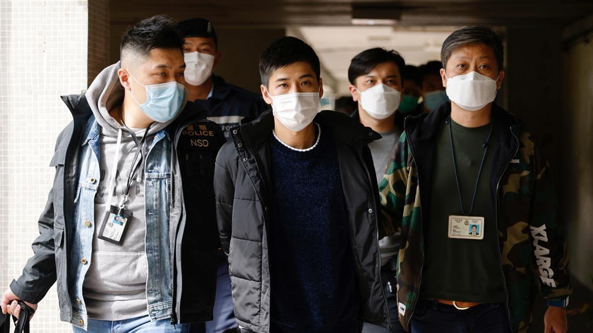 El activista Lester Shum, rodeado de policías durante su detención este lunes en Hong Kong.