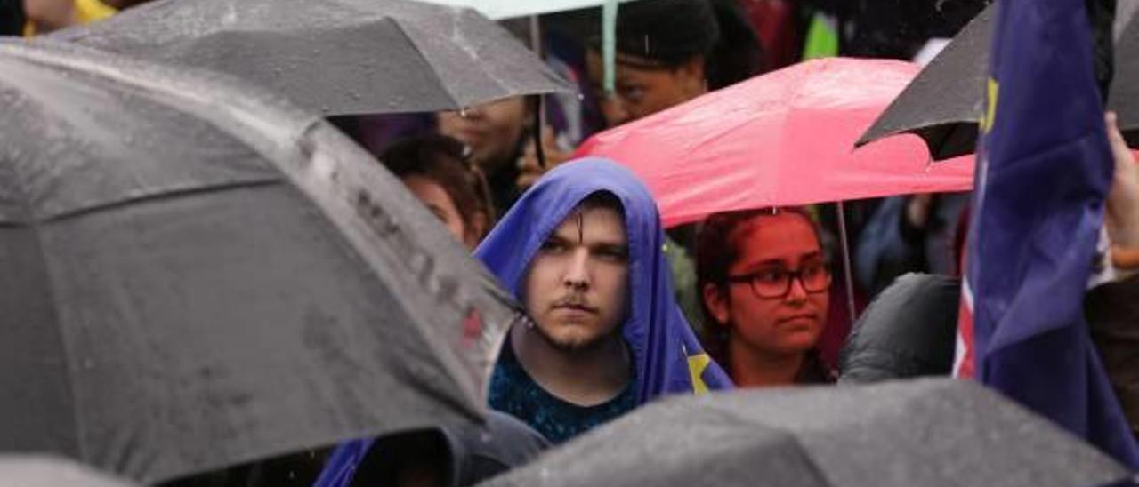 Un joven se protege de la lluvia con la bandera europea durante una protesta esta semana contra el resultado del «Brexit».