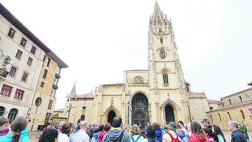 Un grupo de turistas, frente a la Catedral de Oviedo.