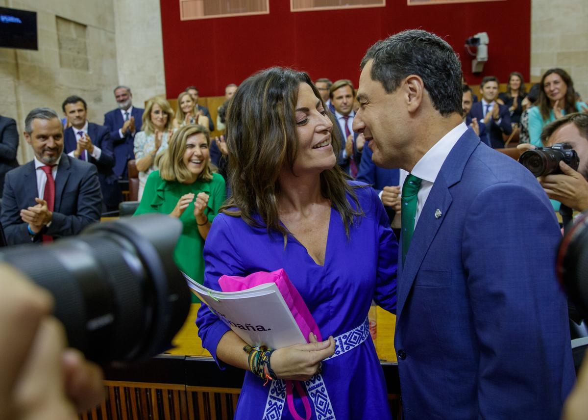 SEVILLA, 21/07/2022.- El presidente de la Junta de Andalucía, Juanma Moreno, es felicitado por la portavoz del grupo parlamentario de Vox Andalucía, Macarena Olona, tras ser investido esta tarde de nuevo como jefe del Ejecutivo autonómico al obtener el respaldo de la mayoría del Parlamento, con los 58 votos de los diputados del PP, que conforman mayoría absoluta en la Cámara, y la abstención de Vox. EFE/Julio Muñoz