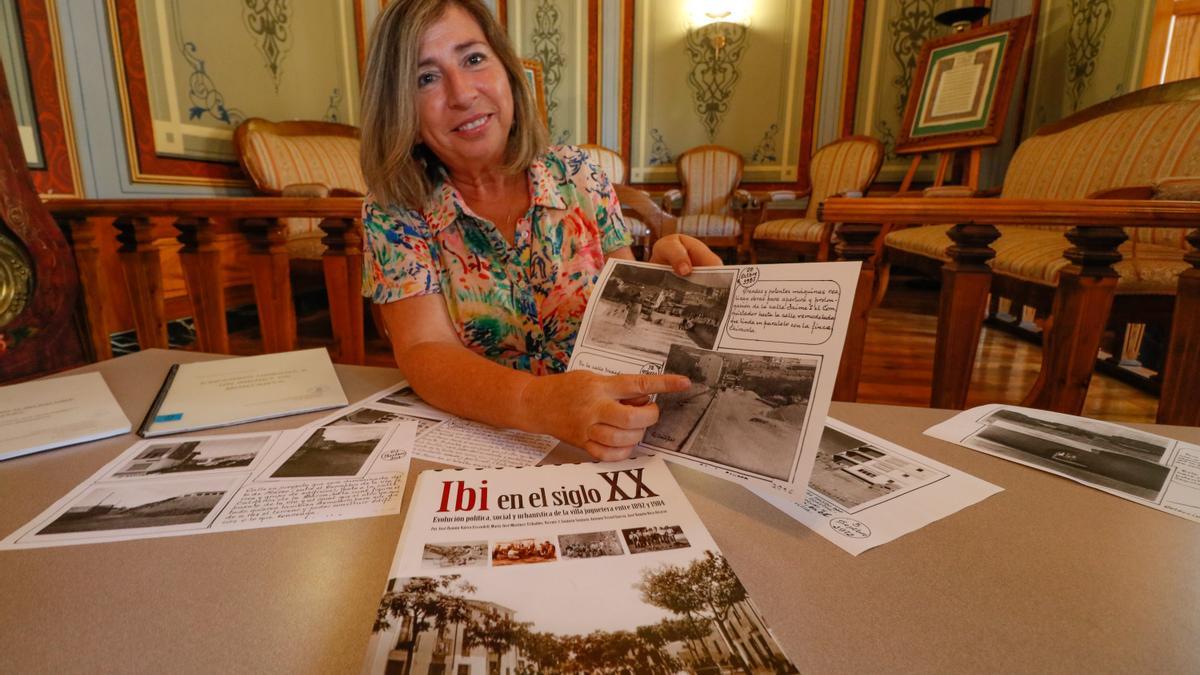 La archivera municipal de Ibi, María José Martínez, una de los cientos de tomelloseros que emigraron a Ibi con sus familias, mostrando imágenes del desarrollo urbano de aquellos años.