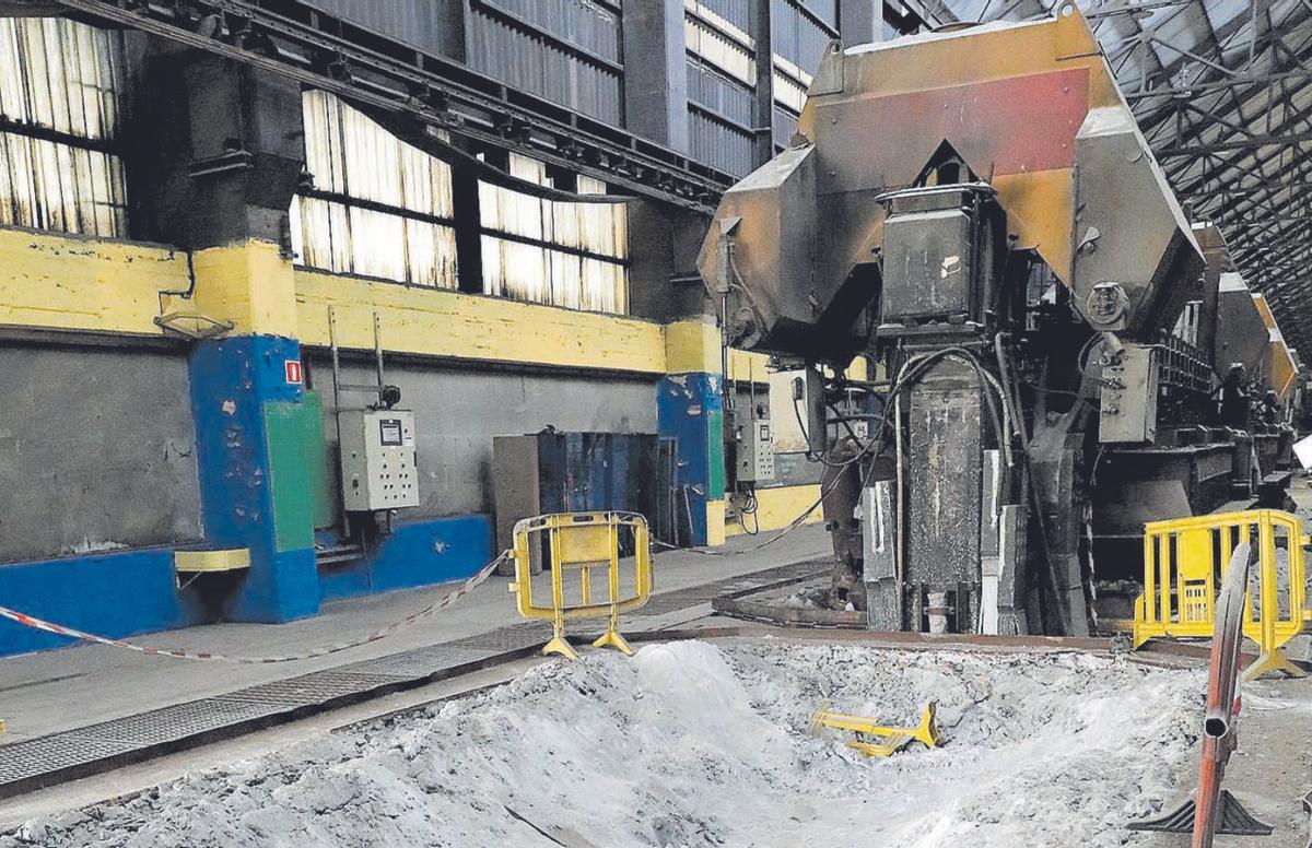 Restos de mineral junto a una línea de cubas electrolíticas en la fábrica avilesina de Alu Ibérica. | M. Villamuza