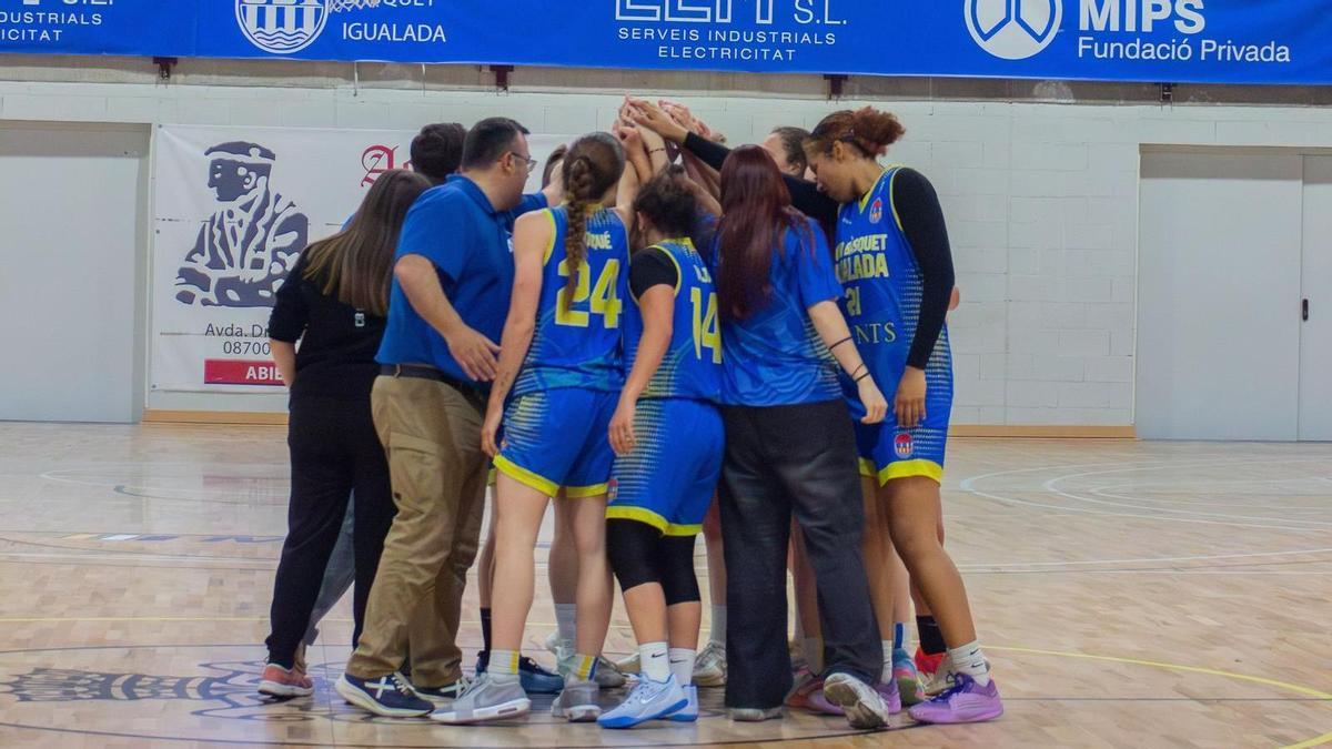 Les jugadores del CB Igualada i l'equip tècnic fent pinya després d'un partit