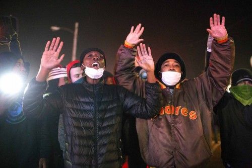 Protesters confront police officers during a second night of rioting in Ferguson, Missouri
