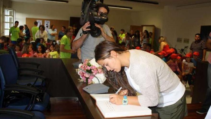 Sofía Toro firma en el libro de honor del Ayuntamiento de Cambre, donde ayer fue recibida por el alcalde. / l. o.
