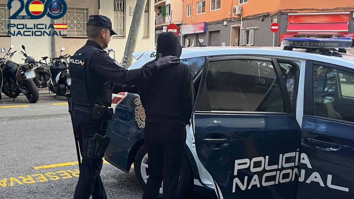 Un agente de la Policía Nacional lleva detenida a la presunta estafadora.