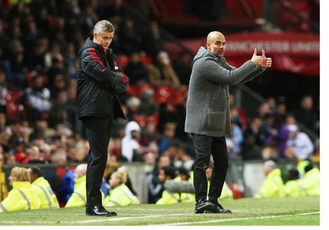 El entrenador Pep Guardiola (d) y Ole Gunnar Solskjaer (i) reaccionan durante un partido de fútbol de la Liga Premier inglesa entre el Manchester United y el Manchester City este miércoles, en Old Trafford en Manchester (Reino Unido).