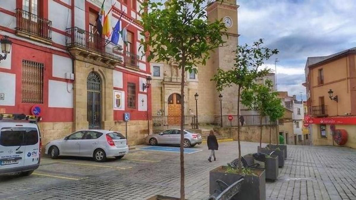 Una persona camina frente al Ayuntamiento de Torrejoncillo.