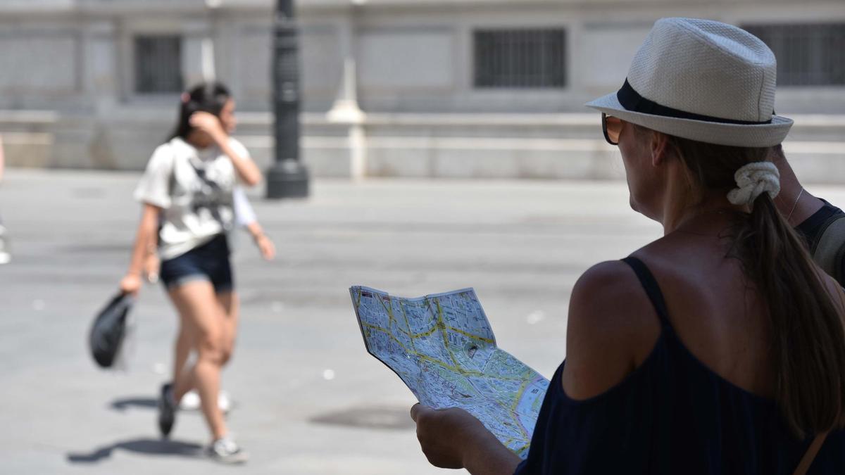 Una turista consulta un mapa de la ciudad en la Avenida de la Constitución. / Jesús Barrera