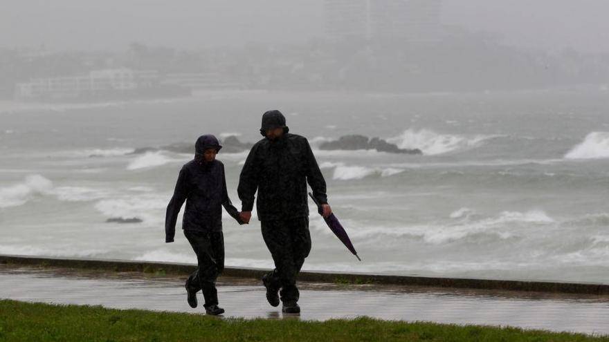 Dos viandantes plantan cara al temporal en Samil. // Ricardo Grobas