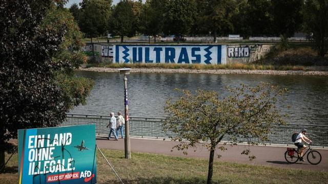 Cartell electoral del partit ultra AfD, vandalitzat amb una pintada (esquerra), a Magdeburg (Alemanya). | RONNY HARTMANN / AFP
