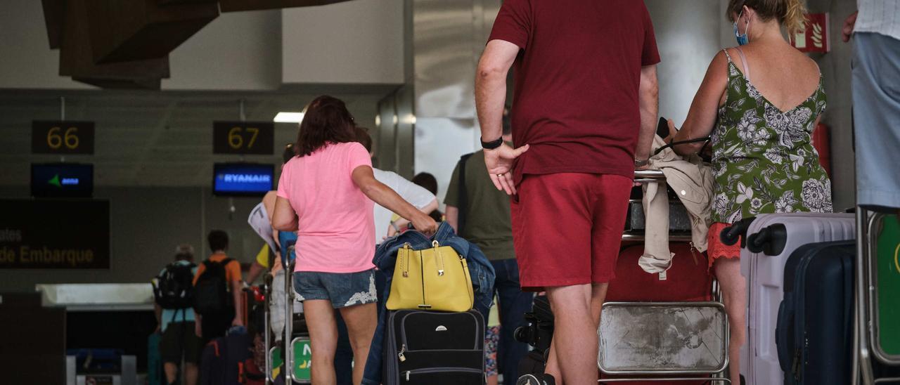 Turistas hacen cola en el aeropuerto para facturar.