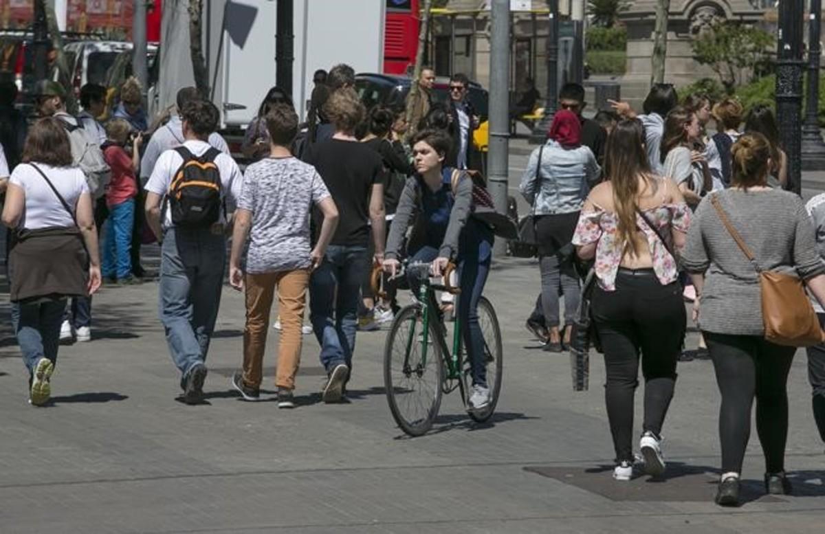 Una ciclista circula por las aceras de la plaza de Catalunya. 