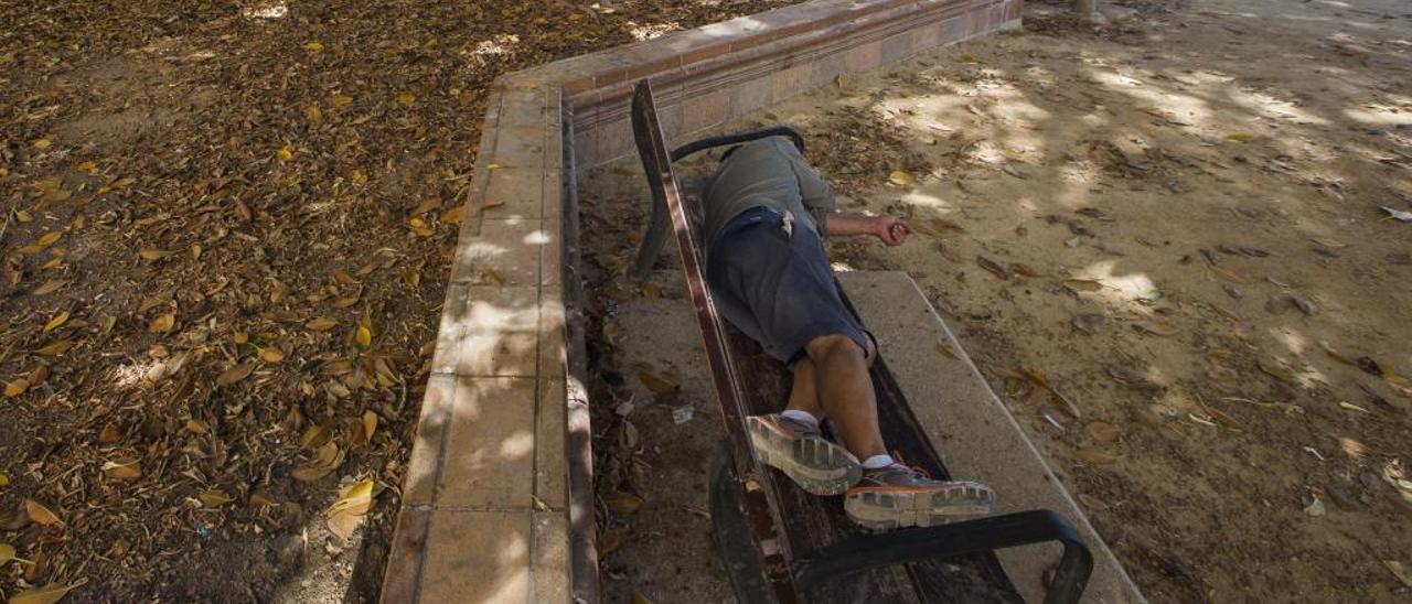 Un hombre durmiendo en un banco en Canalejas.
