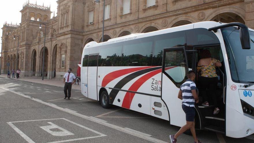 Varios viajeros se suben a un autobús con destino Galicia.