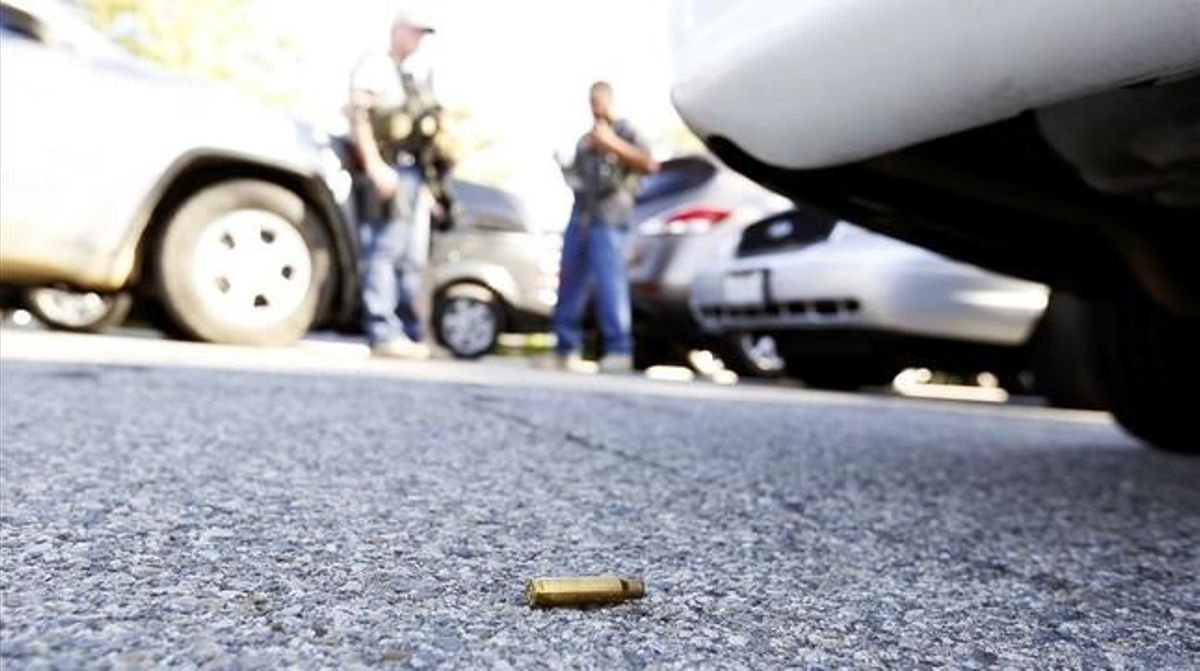 Un casquet de bala a terra utilitzat en el tiroteig, mentre la policia assegura la zona.